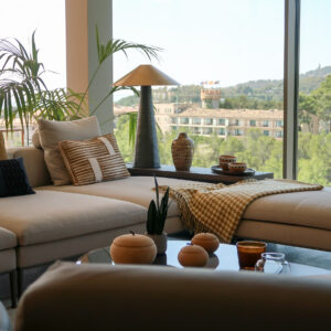 Living room with Cattelan Italia Coffee Table in bronze and smoked glass, B&B Italia sofa and leather armchairs, Burel Factory throw, Visual Comfort lamp and view of Marriott Castillo Hotel Son Vida in the background. Rialto Living accessories.