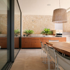 Outdoor kitchen unit with Gozney Pizza Oven, Beefeater Barbecue, bespoke solid wood table and Vibia Wind pendant lights.