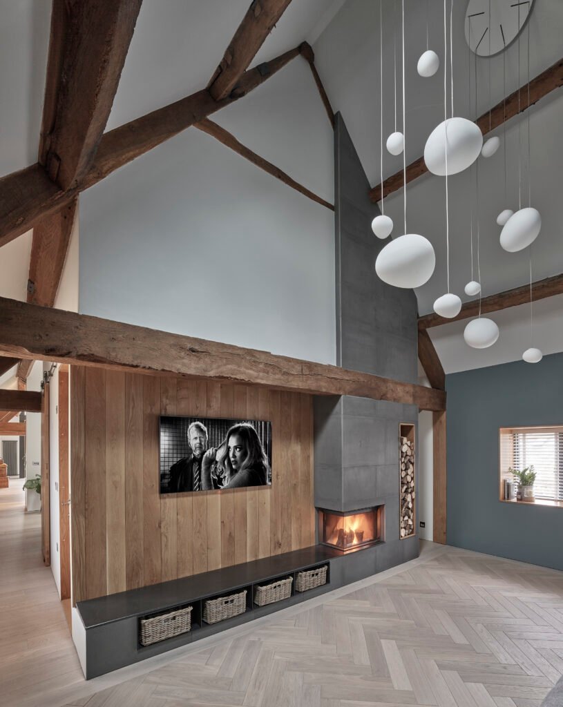 View of snug room with fireplace in the corner and Foscarini Gregg lights.