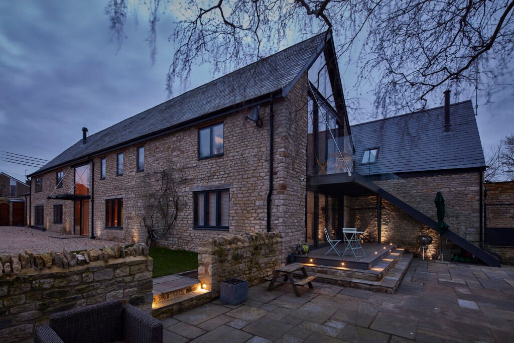 Dusk shot of outside areas on the building, with terrace and balcony and steps to the garden.