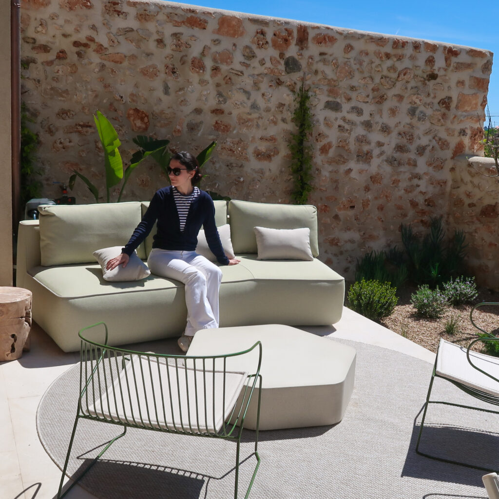 Outdoor area in Casa Raiz. Expormim and Isimar exterior furniture in green fabric and PPC frames. Traditional Mallorcan stone wall as a background.