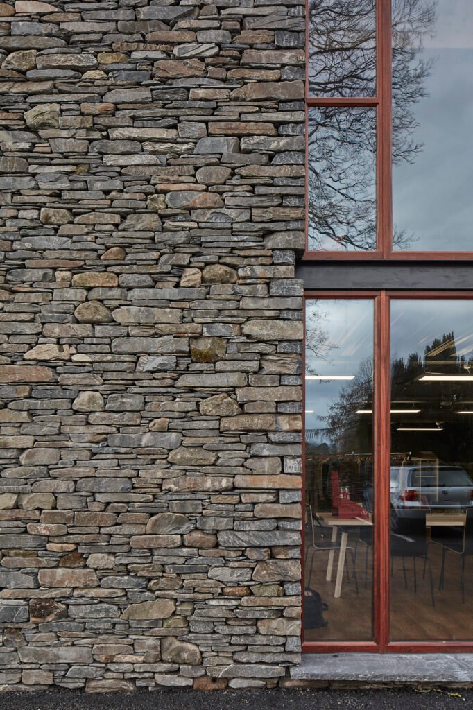 Billy's Space commercial unit in The Lake District. Close up image of the natural stone wall and sapele wood windows.
